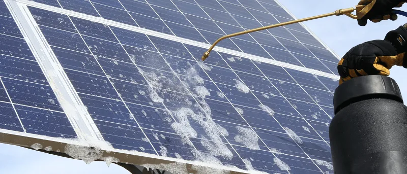 A module surface being cleaned with a controlled water feed